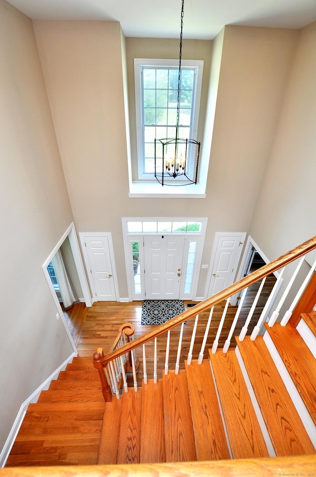 32 Arlington Dr, Avon, CT 06001 - stairway with a chandelier, a towering ceiling, and wood finished floors