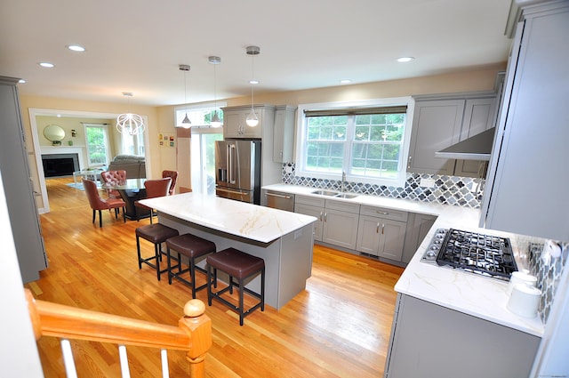32 Arlington Dr, Avon, CT 06001 - kitchen featuring gray cabinetry, appliances with stainless steel finishes, a kitchen bar, tasteful backsplash, and healthy amount of natural light