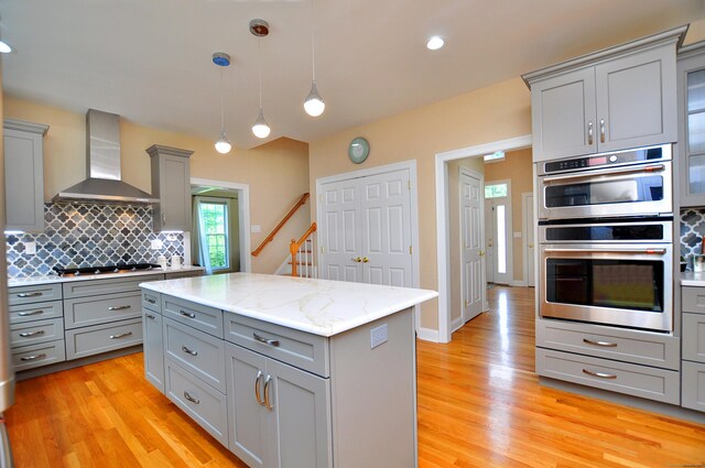 32 Arlington Dr, Avon, CT 06001 - kitchen featuring gray cabinets, wall chimney exhaust hood, stainless steel double oven, and stovetop