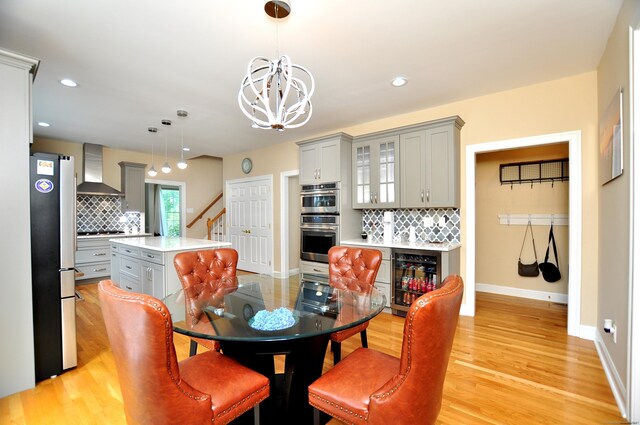 32 Arlington Dr, Avon, CT 06001 - dining space with beverage cooler, a chandelier, light wood finished floors, recessed lighting, and stairs