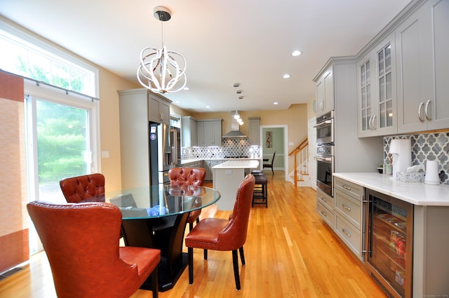 32 Arlington Dr, Avon, CT 06001 - dining area with beverage cooler, a chandelier, stairs, light wood finished floors, and recessed lighting