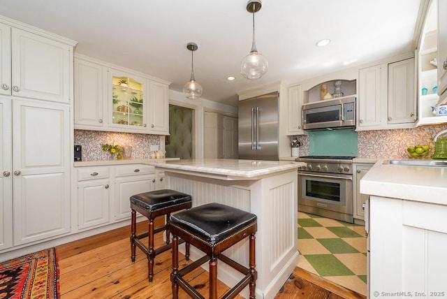 6 Trolley Xing, Old Saybrook, CT 06475 - kitchen with high end appliances, light countertops, backsplash, open shelves, and a kitchen bar