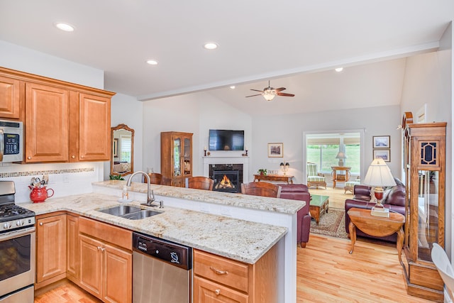 199 Meadow Brook Rd Unit 199, Oxford, CT 06478 - kitchen with stainless steel appliances, lofted ceiling, open floor plan, a peninsula, and light wood-style floors