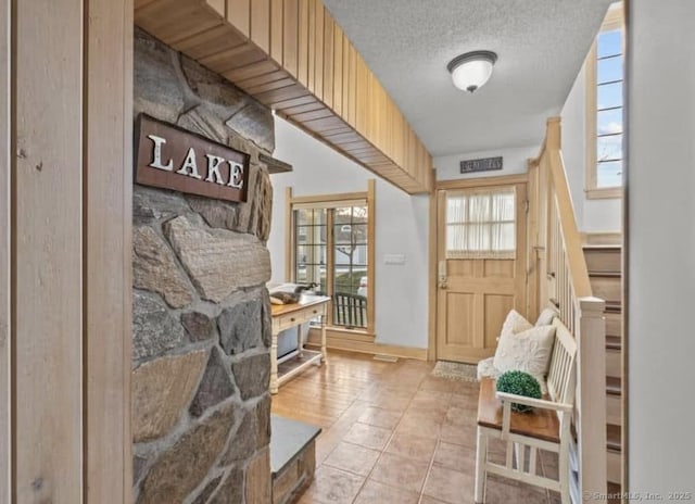 32 Meeks Point Rd, East Hampton, CT 06424 - entrance foyer featuring a textured ceiling, light tile patterned flooring, and stairway