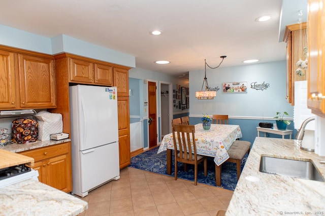 2 Oak Ter, Stratford, CT 06614 - kitchen featuring freestanding refrigerator, light stone counters, brown cabinets, recessed lighting, and light tile patterned flooring