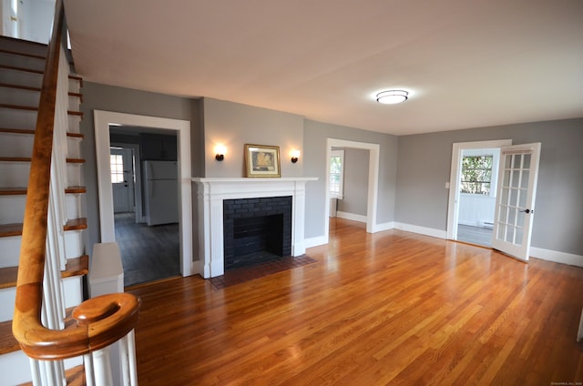 954 Birmingham St, Bridgeport, CT 06606 - living room featuring stairway, light wood-type flooring, a brick fireplace, and a baseboard radiator