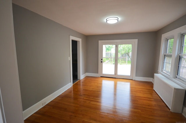 954 Birmingham St, Bridgeport, CT 06606 - empty room featuring radiator, healthy amount of natural light, and wood finished floors
