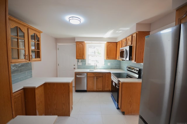 335 Wiklund Ave, Stratford, CT 06614 - kitchen with stainless steel appliances, backsplash, glass insert cabinets, and light countertops