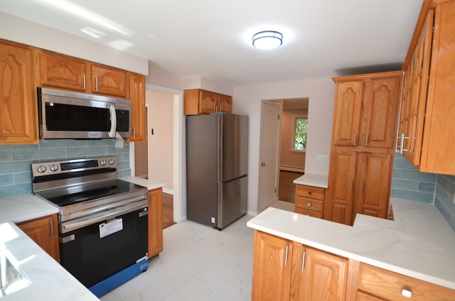 335 Wiklund Ave, Stratford, CT 06614 - kitchen with appliances with stainless steel finishes, backsplash, a baseboard radiator, and light countertops