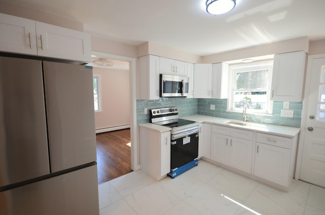 335 Wiklund Ave, Stratford, CT 06614 - kitchen featuring appliances with stainless steel finishes, a baseboard heating unit, light countertops, and white cabinetry