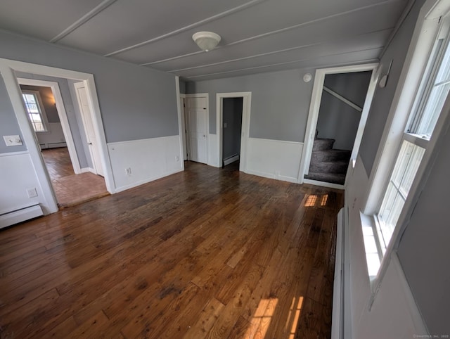 18 Highland St, Plainfield, CT 06354 - unfurnished room featuring stairs, dark wood-style floors, a baseboard heating unit, and wainscoting