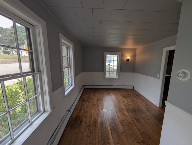 18 Highland St, Plainfield, CT 06354 - empty room with wainscoting, dark wood-type flooring, and a baseboard heating unit