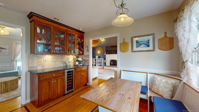 803 Grassy Hill Rd, Orange, CT 06477 - bar featuring wine cooler, light wood-style flooring, decorative backsplash, decorative light fixtures, and a fireplace with raised hearth