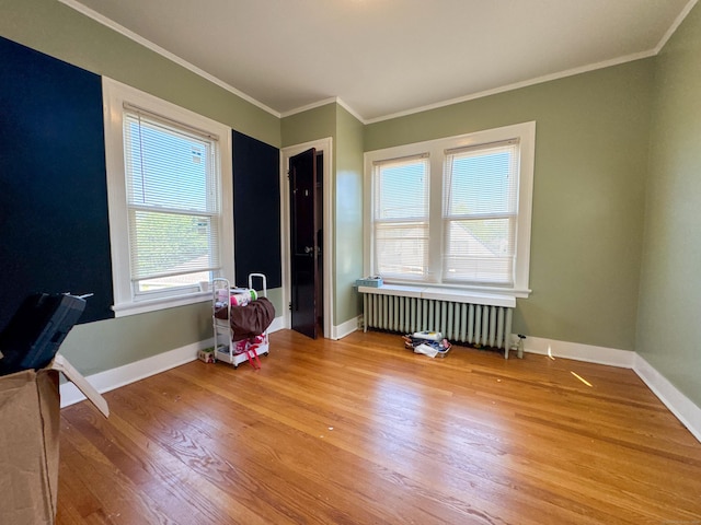 1589 Main St, East Hartford, CT 06108 - empty room featuring radiator, light wood-style floors, and crown molding