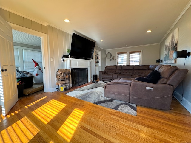 1589 Main St, East Hartford, CT 06108 - living room with wood finished floors, crown molding, a fireplace with flush hearth, built in shelves, and recessed lighting