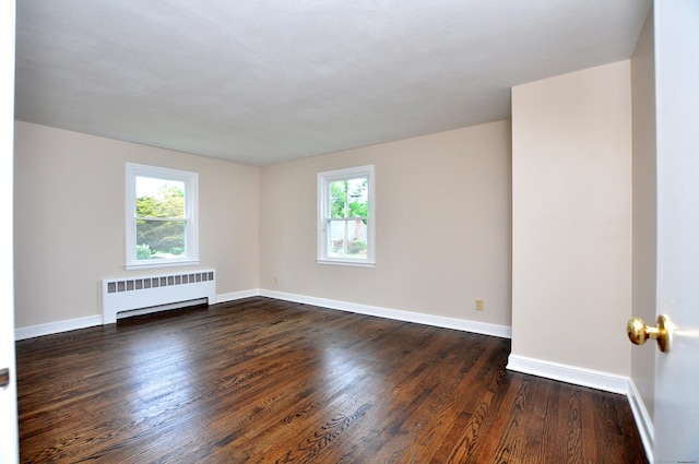 47 Westwood Dr, Simsbury, CT 06070 - empty room with radiator, healthy amount of natural light, and dark wood-style flooring