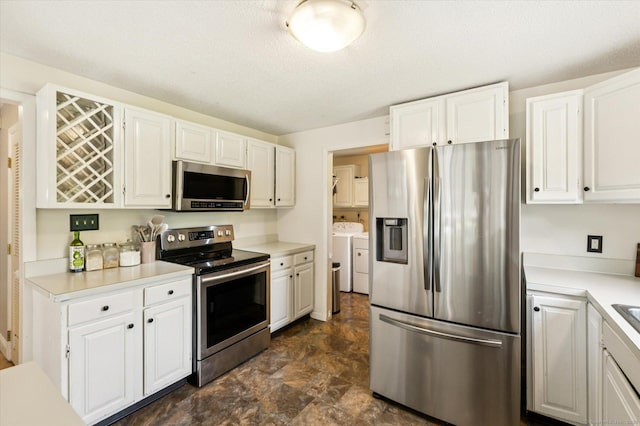 80 Tuckie Rd, Windham, CT 06280 - kitchen featuring appliances with stainless steel finishes, washing machine and clothes dryer, white cabinets, light countertops, and stone finish floors