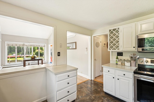 80 Tuckie Rd, Windham, CT 06280 - kitchen with appliances with stainless steel finishes, light countertops, white cabinetry, and stone finish floors