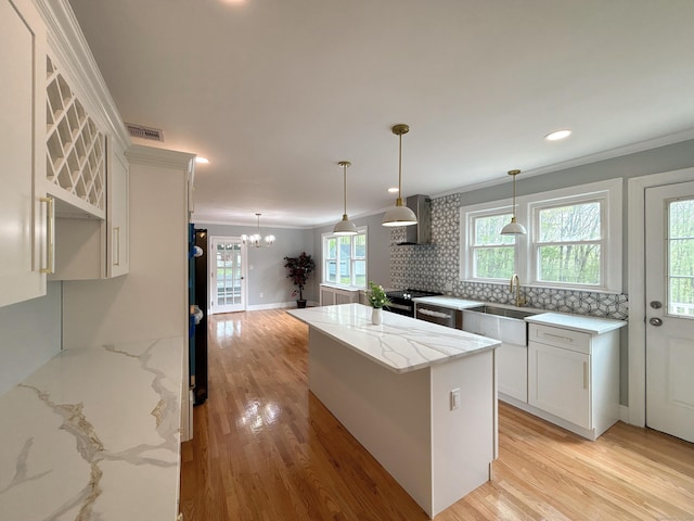 2125 Shepard Ave, Hamden, CT 06518 - kitchen with crown molding, a kitchen island, light wood-style floors, white cabinets, and a chandelier