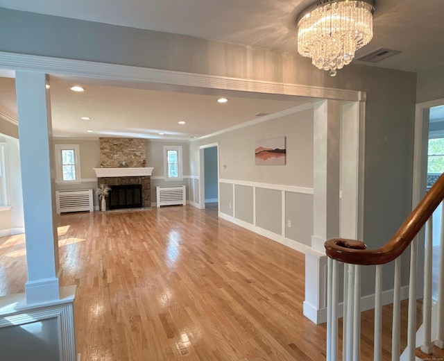2125 Shepard Ave, Hamden, CT 06518 - unfurnished living room with ornamental molding, healthy amount of natural light, a chandelier, light wood-style floors, and a fireplace