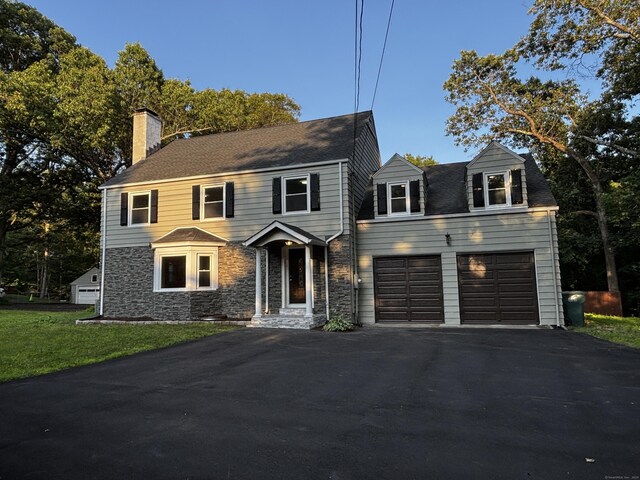 2125 Shepard Ave, Hamden, CT 06518 - view of front of property featuring asphalt driveway, a chimney, a garage, stone siding, and a front yard