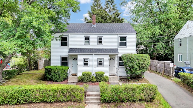 83 Woodlawn Cir E, Hartford, CT 06108 - view of front of property featuring a shingled roof, a chimney, entry steps, and asphalt driveway