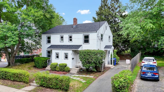 83 Woodlawn Cir E, Hartford, CT 06108 - view of front of house with roof with shingles, a chimney, and driveway