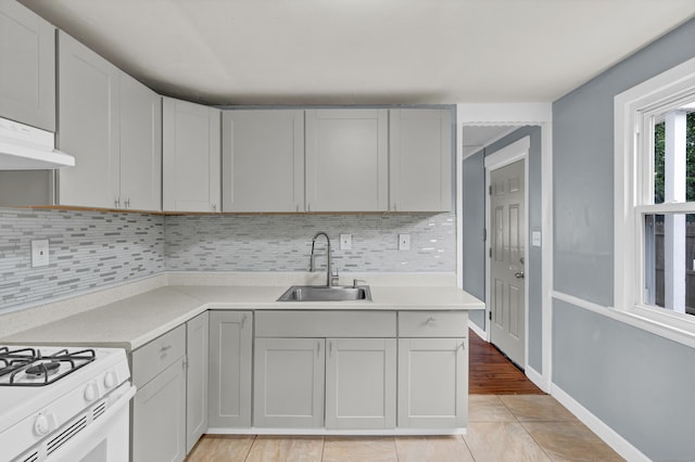 83 Woodlawn Cir E, Hartford, CT 06108 - kitchen with tasteful backsplash, under cabinet range hood, light countertops, and light tile patterned floors
