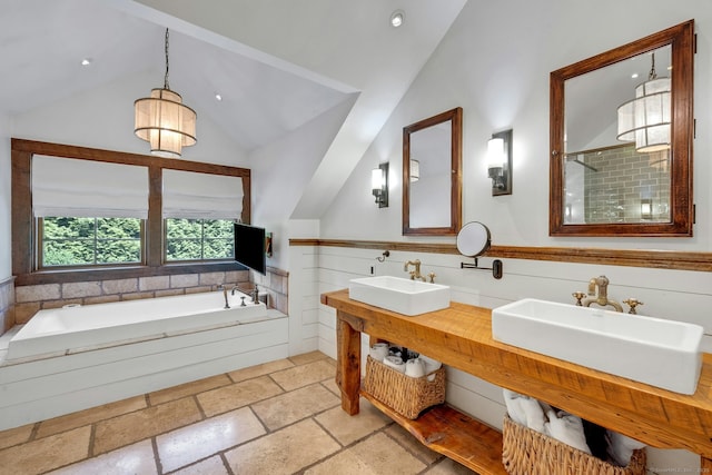 2024 Stratfield Rd, Fairfield, CT 06825 - bathroom featuring vaulted ceiling, a garden tub, double vanity, stone tile flooring, and a tile shower