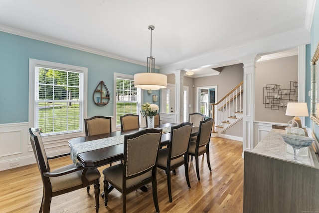 233 Ichabod Rd, Southbury, CT 06488 - dining area with ornate columns, crown molding, light wood-style floors, a decorative wall, and a wainscoted wall