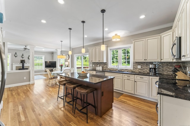 233 Ichabod Rd, Southbury, CT 06488 - kitchen with decorative columns, tasteful backsplash, light wood-type flooring, a breakfast bar, and crown molding