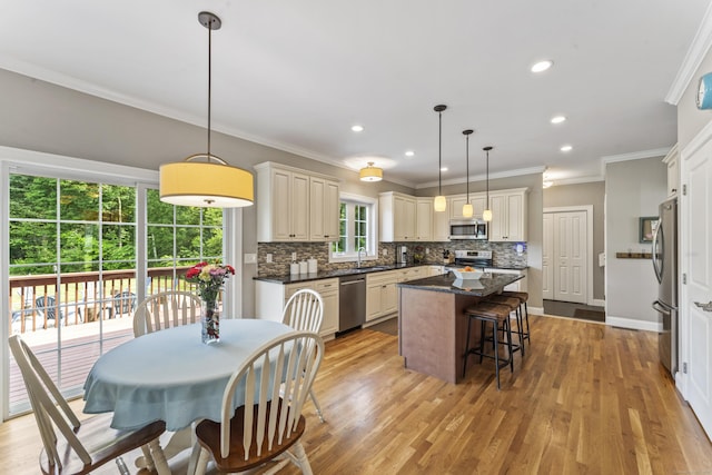 233 Ichabod Rd, Southbury, CT 06488 - kitchen with stainless steel appliances, a center island, backsplash, crown molding, and a breakfast bar area