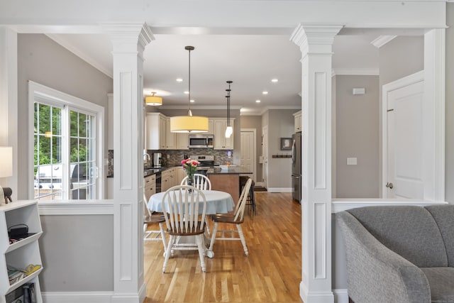 233 Ichabod Rd, Southbury, CT 06488 - dining area with decorative columns, light wood-style floors, crown molding, and recessed lighting