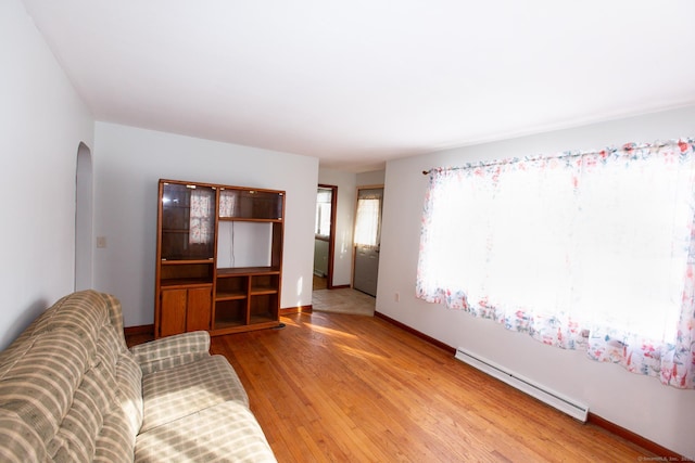 234 Vergason Ave, Norwich, CT 06360 - living area featuring baseboard heating, arched walkways, and light wood finished floors