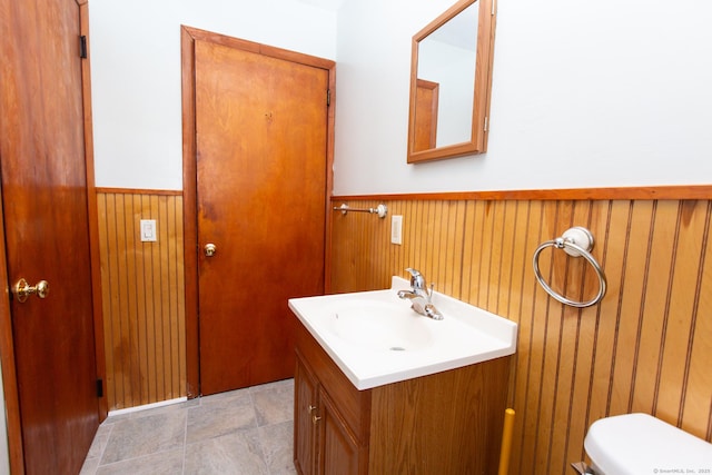 234 Vergason Ave, Norwich, CT 06360 - half bath featuring wainscoting, vanity, wood walls, and stone finish flooring