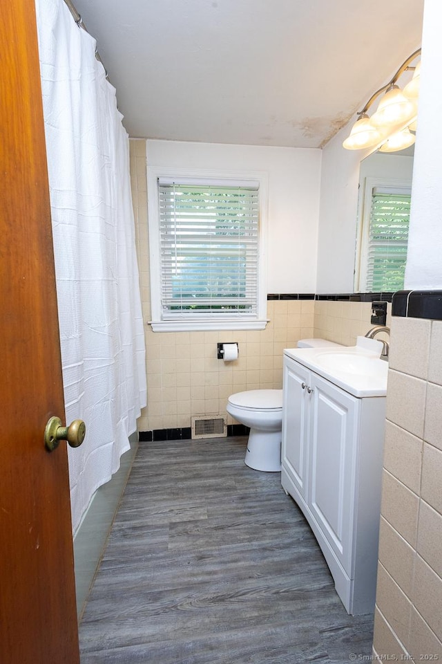 136 Chatham St, Hartford, CT 06112 - bathroom with tile walls, vanity, wood finished floors, curtained shower, and wainscoting