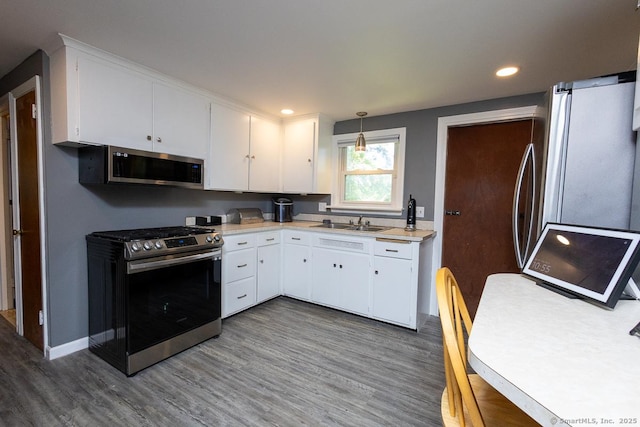 136 Chatham St, Hartford, CT 06112 - kitchen with stainless steel appliances, wood finished floors, light countertops, white cabinetry, and recessed lighting