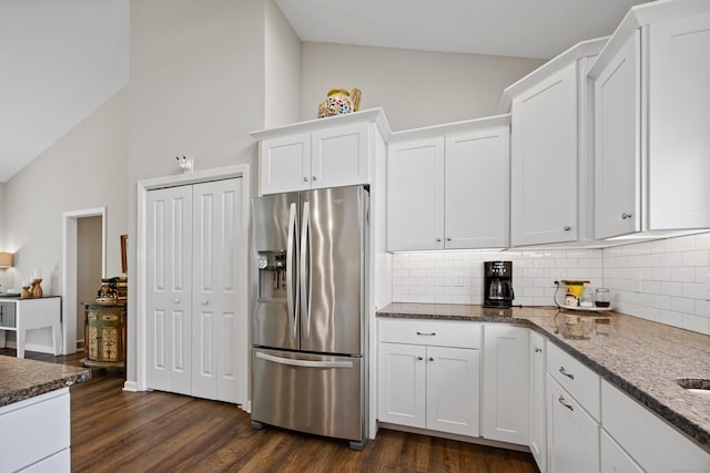 31 Old Oak Ct, Southington, CT 06489 - kitchen with stainless steel fridge, decorative backsplash, white cabinets, dark stone countertops, and high vaulted ceiling