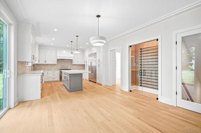28 Pin Oak Ct, Westport, CT 06880 - kitchen featuring high end appliances, light countertops, backsplash, a kitchen island, and white cabinets