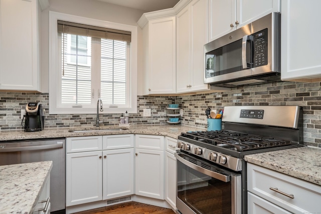 21 Hendricks Ln, Simsbury, CT 06070 - kitchen featuring appliances with stainless steel finishes, white cabinets, backsplash, and light stone counters