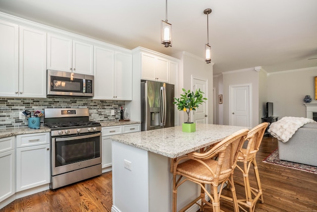 21 Hendricks Ln, Simsbury, CT 06070 - kitchen with stainless steel appliances, dark wood-style floors, crown molding, a center island, and white cabinets