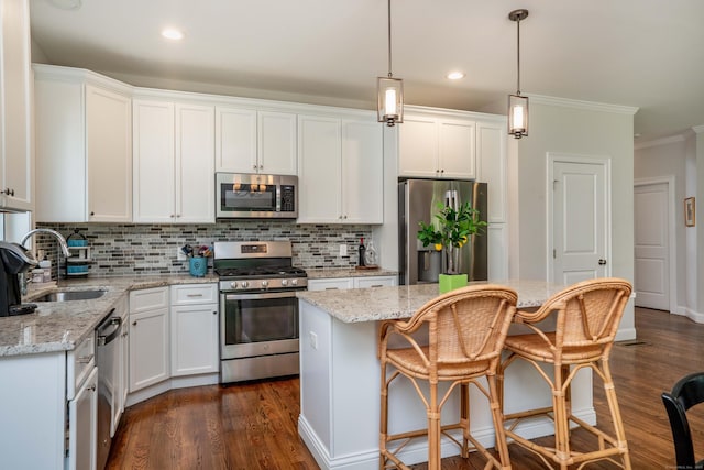 21 Hendricks Ln, Simsbury, CT 06070 - kitchen featuring stainless steel appliances, ornamental molding, tasteful backsplash, a kitchen island, and a kitchen breakfast bar