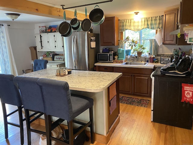 28 Union St, Plymouth, CT 06786 - kitchen with appliances with stainless steel finishes, light countertops, light wood-style flooring, a breakfast bar, and a kitchen island
