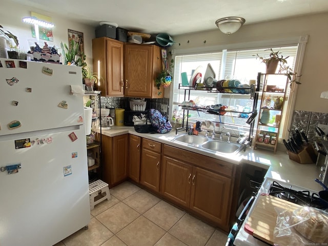28 Union St, Plymouth, CT 06786 - kitchen with freestanding refrigerator, tasteful backsplash, light countertops, light tile patterned floors, and brown cabinets