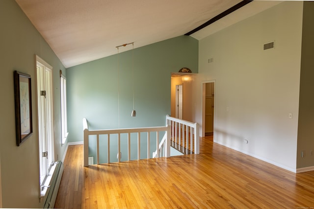 472 Saw Mill Rd, Guilford, CT 06437 - empty room featuring a baseboard heating unit, wood finished floors, and high vaulted ceiling