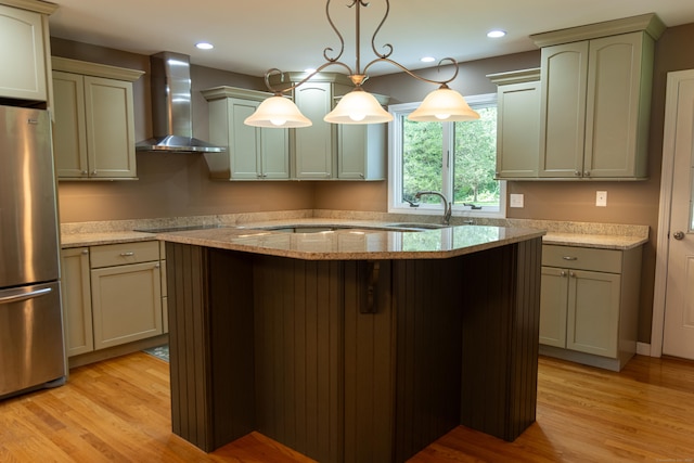 472 Saw Mill Rd, Guilford, CT 06437 - kitchen with wall chimney exhaust hood, freestanding refrigerator, a center island, light wood-type flooring, and light stone counters