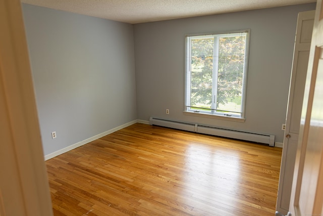 472 Saw Mill Rd, Guilford, CT 06437 - empty room featuring baseboard heating, healthy amount of natural light, light wood-type flooring, and a textured ceiling