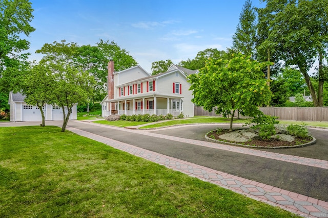 254 W Ave, Darien, CT 06820 - view of front of house featuring driveway, a chimney, a garage, and an outbuilding