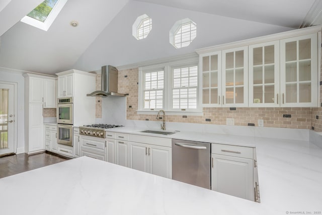 254 W Ave, Darien, CT 06820 - kitchen with appliances with stainless steel finishes, wall chimney range hood, a skylight, light countertops, and plenty of natural light