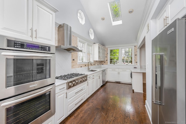 254 W Ave, Darien, CT 06820 - kitchen with appliances with stainless steel finishes, wall chimney exhaust hood, backsplash, light countertops, and vaulted ceiling